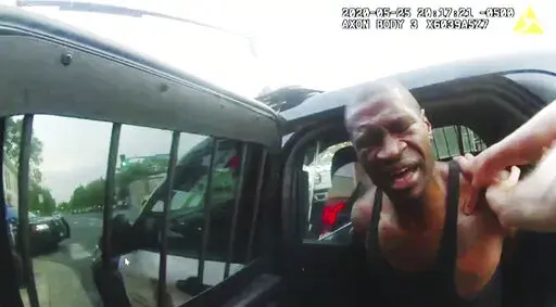 In this image from police body camera video shown as evidence in court, Minneapolis police officers attempt to place George Floyd in a police vehicle, on May 25, 2020, outside Cup Foods in Minneapolis. Former police Officers Tou Thao, J. Alexander Kueng and Thomas Lane are on trial in federal court accused of violating Floyd's civil rights as fellow Officer Derek Chauvin killed him. (Minneapolis Police Department via AP, File)