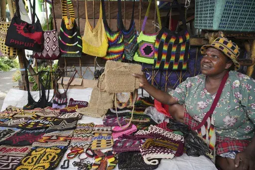 A woman sells traditional handmade bags called Noken at a market in Jayapura, Papua province, Indonesia, Oct. 3, 2024. (AP Photo/Firdia Lisnawati)