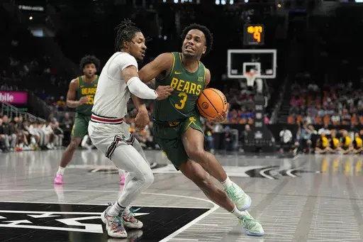 Baylor's Jeremy Roach, right, heads to the basket past Texas Tech's Elijah Hawkins during the first half of an NCAA college basketball game in the quarterfinal round of the Big 12 Conference tournament, Thursday, March 13, 2025, in Kansas City, Mo. (AP Photo/Charlie Riedel)