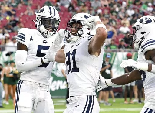 BYU linebacker Max Tooley (31) celebrates after returning an interception for a touchdown during the first half of an NCAA football game against South Florida Saturday, Sept. 3, 2022, in Tampa, Fla. (AP Photo/Jason Behnken)