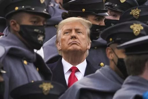 Surrounded by Army cadets, President Donald Trump watches the first half of the 121st Army-Navy Football Game in Michie Stadium at the United States Military Academy, Saturday, Dec. 12, 2020, in West Point, N.Y. Experts in constitutional law and the military say the Insurrection Act gives presidents tremendous power with few restraints. Recent statements by former President Donald Trump raise questions about how he might use it if he wins another term. (AP Photo/Andrew Harnik, File)