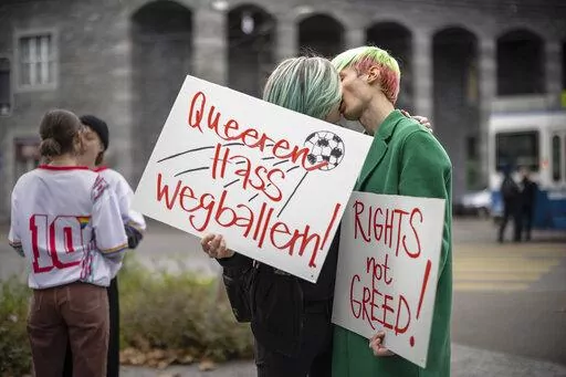 Protestors kiss while holding placards reading "Shoot out queer hate" and "Rights not greed" during a rally to raise awareness of the human rights situation of LGBTQ people in Qatar and FIFA's responsibility, in front of the FIFA Museum in Zurich, Switzerland, Tuesday, Nov. 8, 2022. An ambassador for the World Cup in Qatar has described homosexuality as a "damage in the mind" in an interview with German public broadcaster ZDF only two weeks before the opening of the soccer tournament in the Gulf