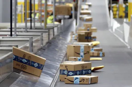 Amazon packages move along a conveyor at an Amazon warehouse facility, Dec. 17, 2019, in Goodyear, Ariz. (AP Photo/Ross D. Franklin, File)