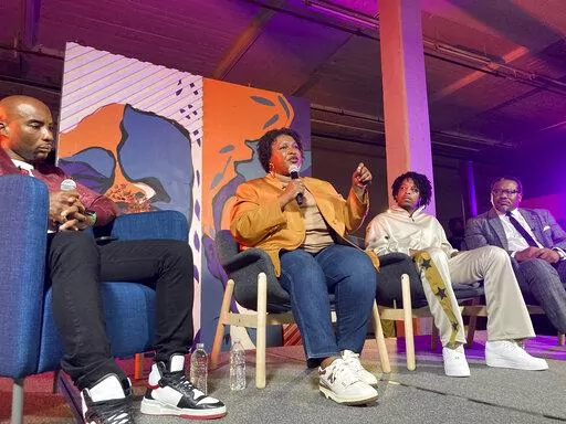 Georgia Democratic candidate for governor Stacey Abrams speaks at a campaign event on Friday, Sept. 9, 2022, in Atlanta, flanked by radio and TV personality Charlamagne tha God, left, rapper 21 Savage and civil rights lawyer Francys Johnson, right. The event is one of a series that Abrams has done to appeal to Black men in her race against Republican incumbent Brian Kemp. (AP Photo/Jeff Amy)