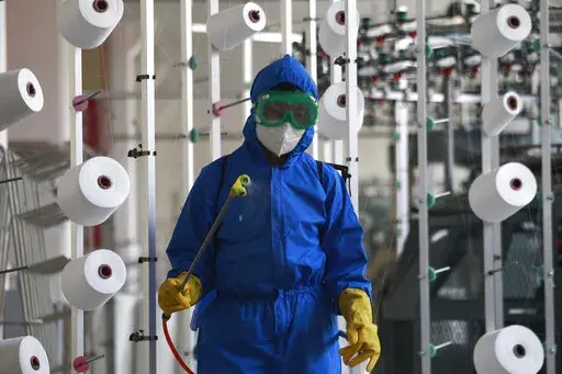 An employee of Songyo Knitwear Factory in Songyo district disinfects the work floor in Pyongyang, North Korea, Wednesday, May 18, 2022, after Kim Jong Un said Tuesday his party would treat the country's outbreak under the state emergency. North Korea said Wednesday more than a million people have already recovered from suspected COVID-19 just a week after disclosing an outbreak it appears to be trying to manage in isolation as global experts express deep concern about the public health threat. (