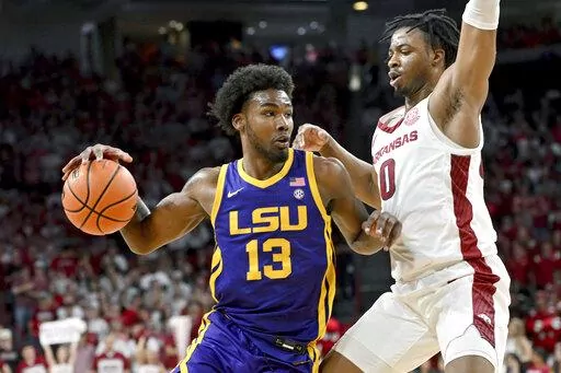 LSU forward Tari Eason (13) tries to drive past Arkansas guard Stanley Umude (0) during the second half of an NCAA college basketball game Wednesday, March 2, 2022, in Fayetteville, Ark. (AP Photo/Michael Woods)