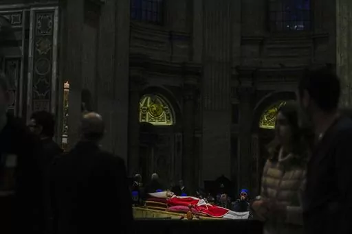The body of the late Pope Emeritus Benedict XVI lies in state in St. Peter's Basilica at the Vatican, as mourners file by to pay tribute, on Jan. 4, 2023. Benedict died Dec. 31, 2022. He was 95. (AP Photo/Alessandra Tarantino)