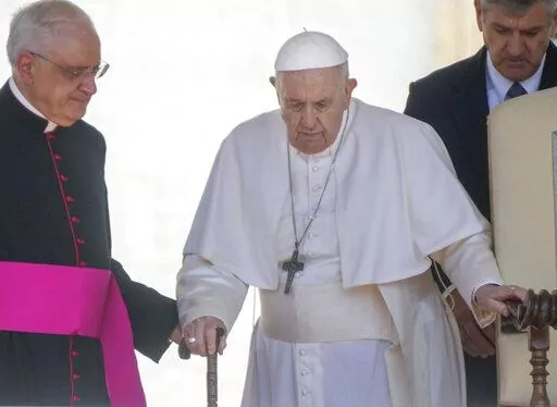 Pope Francis is helped by his aide Monsignor Leonardo Sapienza, left, as he walks with a cane to his weekly general audience in St. Peter's Square at The Vatican, on June 1, 2022. Pope Francis has revealed in an interview published Sunday Dec. 18, 2022 that shortly after being elected pontiff in 2013 he wrote a resignation letter in case medical problems impede him from carrying out duties. (AP Photo/Gregorio Borgia, File)