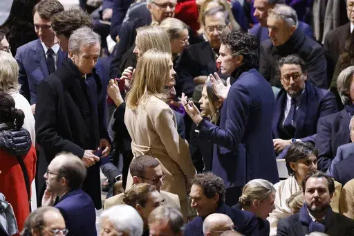 CEO of LVMH Bernard Arnault, left, Antoine Arnault, CEO of Berluti , center right, and members of the Arnault family talk in Notre Dame Cathedral before France's iconic cathedral is formally reopening its doors for the first time since a devastating fire nearly destroyed the 861-year-old landmark in 2019, Saturday Dec.7, 2024 in Paris. (Ludovic Marin/Pool via AP, File)