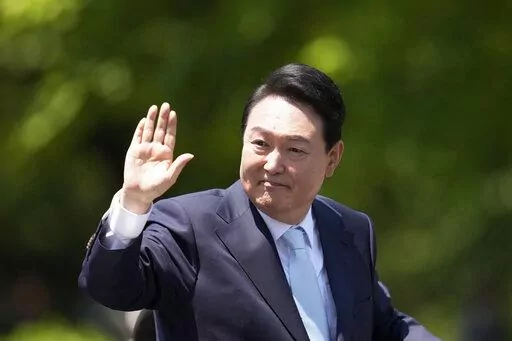 South Korea's new President Yoon Suk Yeol waves from a car after the Presidential Inauguration outside the National Assembly in Seoul, South Korea, Tuesday, May 10, 2022. (AP Photo/Lee Jin-man)