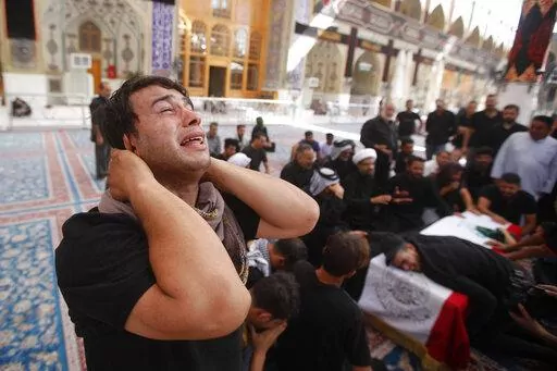 Relatives attend a funeral of a man killed during clashes with security in Baghdad during his funeral in Najaf, Iraq, Tuesday, Aug. 30, 2022. An influential Shiite cleric Muqtada al-Sadr announced Monday that he will resign from Iraqi politics, and hundreds of his angry followers responded by storming the government palace. The move sparked violent clashes with security forces in which at least 15 protesters were killed. (AP Photo/Anmar Khalil)