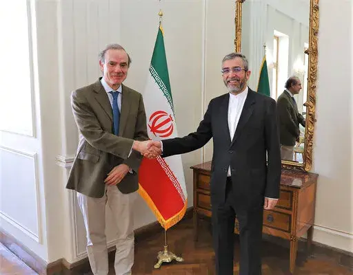 In this photo released by the Iranian Foreign Ministry, Enrique Mora, a leading European Union diplomat, left, shakes hands with Iran's top nuclear negotiator Ali Bagheri Kani in Tehran, Iran, Sunday, March 27, 2022. Mora held talks in Tehran amid hopes that an agreement to restore Iran's tattered nuclear deal with world powers could be completed. (Iranian Foreign Ministry via AP)