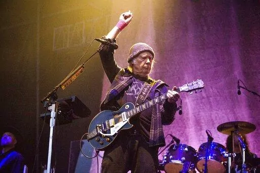 In this May 25, 2019, photo, Neil Young performs at the BottleRock Napa Valley Music Festival at Napa Valley Expo in Napa, Calif. Following protests of Spotify kicked off by Young over the spread of COVID-19 vaccine misinformation, the music streaming service said Sunday, Jan. 30, 2022, that it will add content advisories before podcasts discussing the virus. The singer on Wednesday, Jan. 26, had his music removed from Spotify after the tech giant declined to remove episodes of “The Joe Rogan 