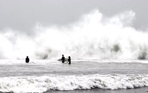 Surfers brave the waves during a rain storm at Venice Beach in Los Angeles on Saturday, Jan. 14, 2023. (Keith Birmingham/The Orange County Register via AP)