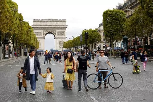 People walk on the champs Elysees avenue during the "day without cars", with the Arc de Triomphe in background, in Paris, on Sept. 22, 2019. Conservatives and conspiracy theorists are increasingly convinced the concept of a “15-minute city” is the latest nefarious plot to curtail individual freedoms. But urban experts and city officials say the design principle -- recently embraced by cities including Oxford, England, Paris, and Cleveland, Ohio -- is simply about building more compact, walka
