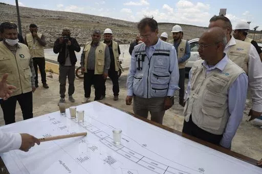 U.N. Deputy Regional Humanitarian Coordinator for the Syria Crisis David Carden, center, inspects a wastewater treatment project in the village of Bhora, in Idlib province, Syria, Tuesday, May 14, 2024. Syria's devastating civil war, now in its 14th year, remains largely frozen and so are efforts to find a viable political solution to end it, while millions of Syrians have been pulled into poverty, and struggle with accessing food and health care as the economy deteriorates across the country's 