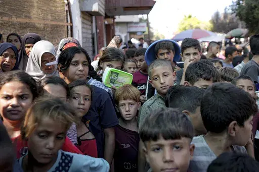 Palestinians line up for food distribution in Deir al-Balah, Gaza Strip, on Oct. 17, 2024. (AP Photo/Abdel Kareem Hana, File)