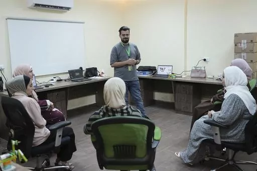 In this photo taken Tuesday, June 13, 2023, Jaser Alharasis, co-founder and CEO of a start-up that trains young Jordanians in robotics and artificial intelligence called Robotna, talks to his team in east Amman, Jordan. (AP Photo/Raad Adayleh)