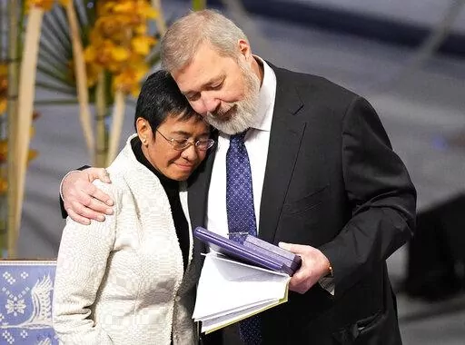 Nobel Peace Prize winners Dmitry Muratov from Russia, right, and Maria Ressa of the Philippines embrace during the Nobel Peace Prize ceremony at Oslo City Hall, Norway, Friday, Dec. 10, 2021.  For the two journalists who won the Nobel Peace Prize in 2021, the past year has not been easy. Dmitry Muratov of Russia and Maria Ressa of the Philippines have been fighting for the survival of their news organizations, defying government efforts to silence them. (AP Photo/Alexander Zemlianichenko, File)