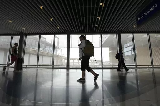 Carol Giuliani, who is a member of the Dementia-Friendly Airports Working group and works as a travel companion for seniors with dementia, walks through Terminal 3 at Phoenix Sky Harbor International Airport after bringing a client from Minnesota Wednesday, Aug. 23, 2023, in Phoenix. “Ninety percent of the time it’s a family member that hires me,” said Giuliani, while seated at Phoenix Sky Harbor after escorting an elderly man on a flight. “The one I did today, (the wife) was like ‘tha