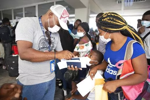 Etienne Ilienses checks her family's papers for a flight to Chile, at the Toussaint Louverture International Airport, in Port-au-Prince, Haiti, Sunday, Jan. 30, 2022. Ilienses said she was sent back to Haiti from Texas on Dec. 14 and talked to the AP before flying to Santiago with her three children on a Jan. 30 charter flight on SKY. “To get to the USA, I braved hell,” she said. Still, she did not dismiss doing it again “because Haiti offers nothing to its children. We are forced to suffe
