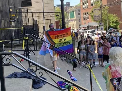 A performer advocates for LGBTQ+ youth on the steps of Scranton City Hall Saturday, June 1, 2024, in Scranton, Pa. Pride Month is kicking off around the world with parades and festivals in cities large and small. The annual celebrations of LGBTQ+ people and culture began Saturday against a complicated backdrop of backlashes. (AP Photo/Jeff McMillan)