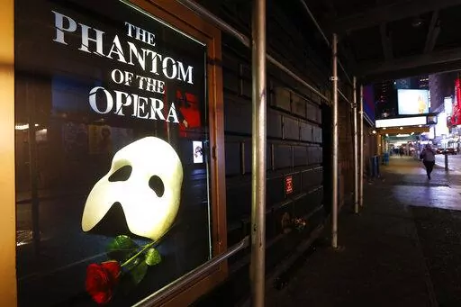 A poster advertising "The Phantom of the Opera," is displayed on the shuttered Majestic Theatre in New York, March 12, 2020. Broadway's longest-running show will play its final performance on Broadway on Feb. 18, 2023, a spokesperson told The Associated Press on Friday, Sept. 16, 2022. The closing will come less than a month after its 35th anniversary. (AP Photo/Kathy Willens, File)