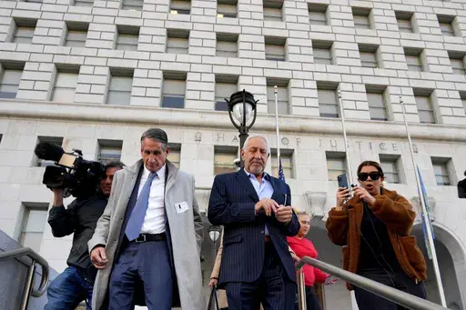 Attorneys Mark Geragos, center, and Bryan Freedman, left, leave before a news conference held by Los Angeles County District Attorney Nathan Hochman regarding resentencing of Erik and Lyle Menendez for the murders of their parents, in Los Angeles on Friday, Jan. 3, 2025. (AP Photo/Damian Dovarganes)
