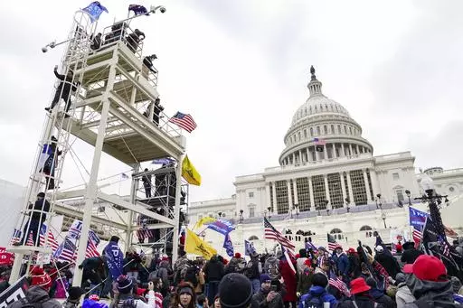 Violent insurrectionists breach the U.S. Capitol in Washington, Jan. 6, 2021. A former government employee has been charged with repeatedly submitting fake tips to the FBI reporting that several of his co-workers in the intelligence community were part of a mob that attacked the U.S. Capitol on Jan. 6. Court records unsealed on Friday, May 3, 2024, say that Miguel Eugenio Zapata was arrested in Chantilly, Virginia, on Thursday on a charge that he made false statements to law enforcement. (AP Pho