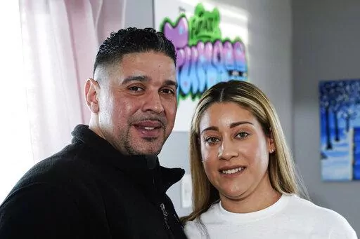 Eladio and Melissa Guzman pose for photographs, Monday, April 4, 2022, in Hicksville, N.Y. The couple, who endured the war on drugs, including jail time, are now eager to open a recreational marijuana dispensary in New York. (AP Photo/Frank Franklin II)