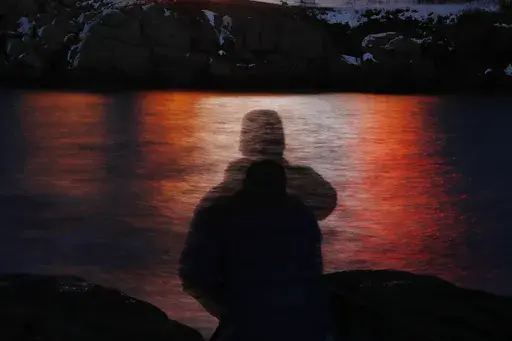 In this photo made with a long exposure, a man is silhouetted against lights reflected in the waters off Cape Neddick in Maine on Dec. 11, 2017. Federal health advisers are considering the first request to approve the mind-altering club drug MDMA as a treatment for PTSD. The advisers to the Food and Drug Administration are scheduled to vote on the drug's safety and effectiveness Tuesday, June 4, 2024, potentially setting the stage for federal approval later this year. (AP Photo/Robert F. Bukaty,