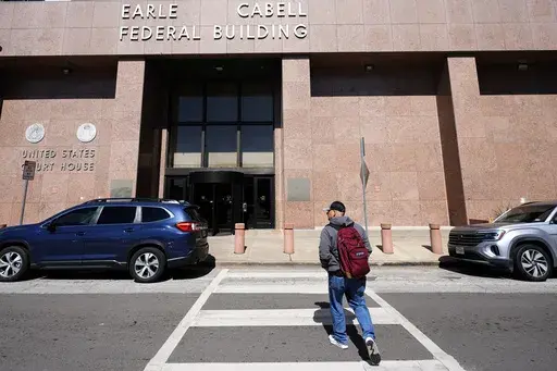 A man walks to the Earle Cabell Federal Building in downtown Dallas, Monday, Feb. 24, 2025. (AP Photo/LM Otero)