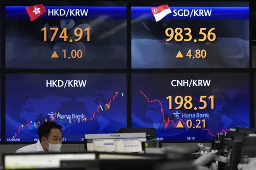 A currency trader watches computer monitors near the screens showing the foreign exchange rates at a foreign exchange dealing room in Seoul, South Korea, Tuesday, Sept. 13, 2022. Asian stocks followed Wall Street higher on Tuesday ahead of data traders hope will show surging U.S. inflation eased in August, reducing pressure for more interest rate hikes. (AP Photo/Ahn Young-joon)