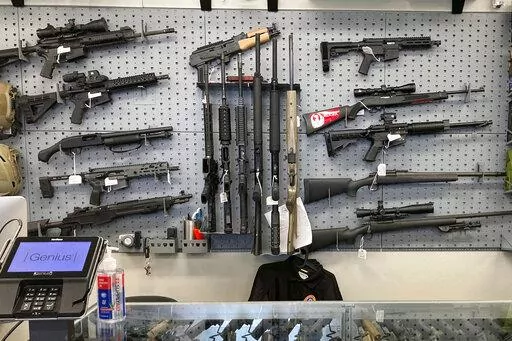 Firearms are displayed at a gun shop in Salem, Ore., on Feb. 19, 2021. An Oregon judge on Tuesday, Dec. 13, 2022, extended an earlier order blocking a key part of a new, voter-approved gun law and was hearing lengthy arguments on whether to also prevent the law's ban on high-capacity magazines from taking effect. (AP Photo/Andrew Selsky, File)