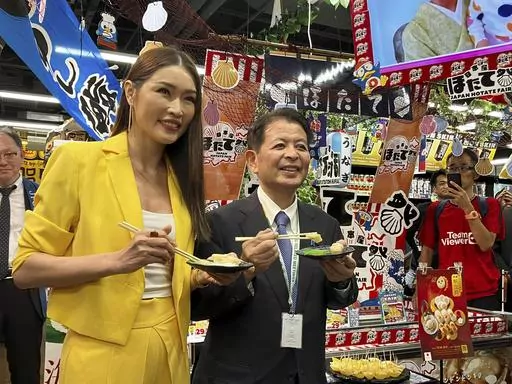 Japanese Agriculture Minister Ichiro Miyashita, right, and Malaysian celebrity Amber Chia attend an event at Japanese store, Don Don Donki in Kuala Lumpur Wednesday, Oct. 4, 2023 to promote the safety and deliciousness of Japanese scallops to shoppers. Japan hopes to resolve the issue of China's ban on its seafood within the scope of the World Trade Organization ambit and will hold food fairs overseas to bolster seafood exports amid safety concerns over the release of treated water from the Fuku