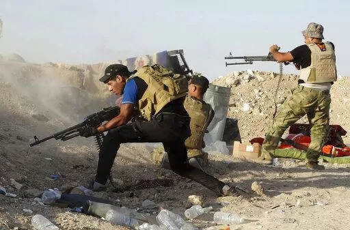In this Monday, June 15, 2015, Iraqi security forces defend their positions against an Islamic State group attack in Husaybah, 8 kilometers (5 miles) east of Ramadi, Iraq. (AP Photo, File)