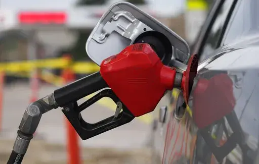 A motorist fills up the tank on a sedan, on July 22, 2022, in Saratoga, Wyo. Falling gas prices gave Americans a slight break from the pain of high inflation last month, though the surge in overall prices slowed only modestly from the four-decade high it reached in June.  (AP Photo/David Zalubowski, File)