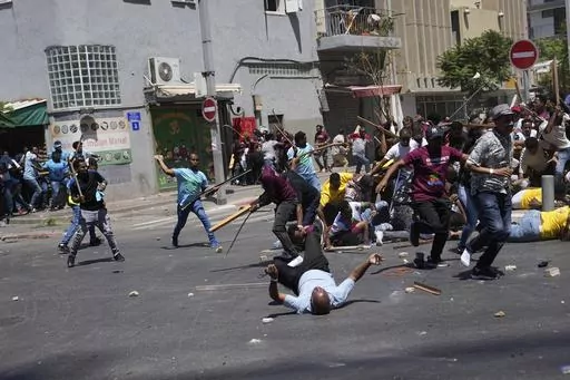 Anti-Eritrean government activists, left, clash with supporters of the Eritrean government, in Tel Aviv, Israel, Saturday, Sept. 2, 2023. Hundreds of Eritrean asylum seekers smashed shop windows and police cars in Tel Aviv on Saturday and clashed with police during a protest against an event organized by the Eritrea Embassy. The Israeli police said 27 officers were injured in the clashes, and at least three protesters were shot when police opened fire with live rounds when they felt "real danger