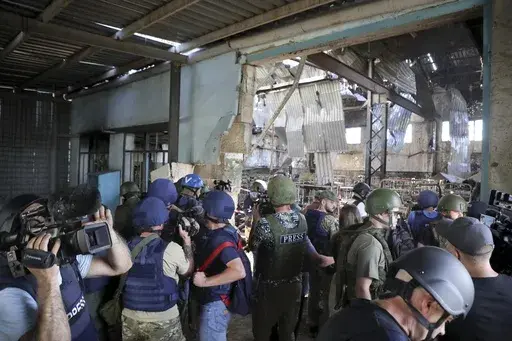 Journalists visit the destroyed barracks at the Russian-controlled Olenivka prison holding Ukrainian POWs in eastern Ukraine, on Aug. 10, 2022. Russia blamed Ukraine at the time but interviews with survivors witnesses and families of the missing as well as an internal U.N. analysis pointed to Russia as the culprit two years later. (AP Photo/File)