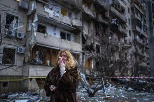 Natali Sevriukova reacts next to her house following a rocket attack the city of Kyiv, Ukraine, on Feb. 25, 2022. By ending 77 years of almost uninterrupted peace in Europe, war in Ukraine war has joined the dawn of the nuclear age and the birth of manned spaceflight as a watershed in history. After nearly a half-year of fighting, tens of thousands of dead and wounded on both sides, massive disruptions to supplies of energy, food and financial stability, the world is no longer as it was.(AP Phot