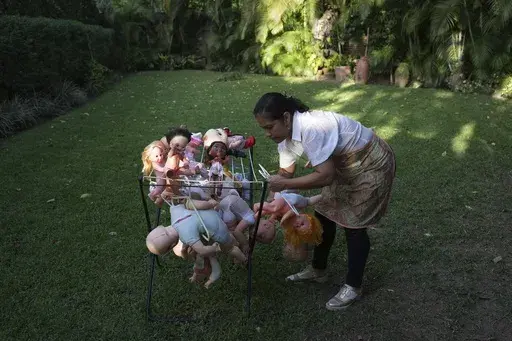 Irelis Baldirio hangs laundered used dolls to dry at the non-profit foundation Hospital de los Peluches, or Hospital of Stuffed Animals, where recycled toys are restored to be donated to vulnerable children as Christmas presents, in Caracas, Venezuela, Thursday, Dec. 5, 2024. (AP Photo/Ariana Cubillos)