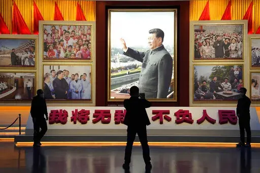 A portrait of Chinese President Xi Jinping is displayed near the words that means "I will put aside my own well-being for the good of my People" at the Museum of the Communist Party of China in Beijing, Wednesday, Oct. 12, 2022. For decades Chinese journalist Ho Pin has successfully predicted rising newcomers in the Chinese Communist Party, and says that leader Xi Jinping is so powerful, there is little point in predicting the leadership line up to be announced at the Communist Party congress th