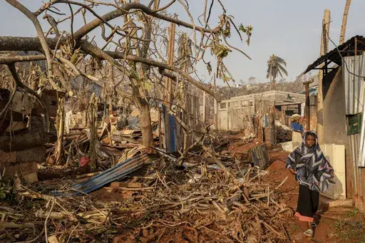 A girl walks amidst destruction in Mbouyougou, Mayotte, Saturday, Dec. 21, 2024. (AP Photo/Adrienne Surprenant)