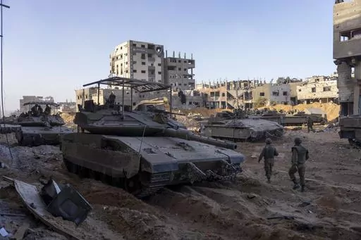Israeli army troops are seen next to a destroyed building during a ground operation in the Gaza Strip on Nov. 8, 2023. As the military sets its sights on southern Gaza in its campaign to stamp out Hamas, key challenges loom. International patience for a protracted invasion has begun to wear thin. And with some 2 million displaced Gaza residents staying in crowded shelters in the south in dire conditions, a broad military offensive there could unleash a new humanitarian disaster during the cold, 
