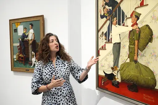 Aviva Lehmann, Heritage Auction's senior vice president of American art, responds to a question as she stands by paintings in Dallas, Thursday, Oct. 17, 2024, that are some of many works from the Boy Scouts of America's art collection — including some paintings by Norman Rockwell — that will go up for auction this month to help compensate tens of thousands of people, mainly men, who were sexually abused while in scouting. (AP Photo/Tony Gutierrez)