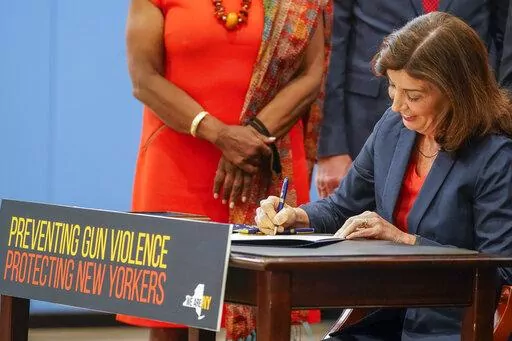 New York Gov. Kathy Hochul signs a package of bills to strengthen gun laws, Monday, June 6, 2022, in New York. New York has strengthened gun laws as part of a series of laws signed this week by Gov. Kathy Hochul with the hope to lessen gun violence and gun-related deaths. Hochul, a Democrat, signed 10 gun-related bills Monday. (AP Photo/Mary Altaffer)