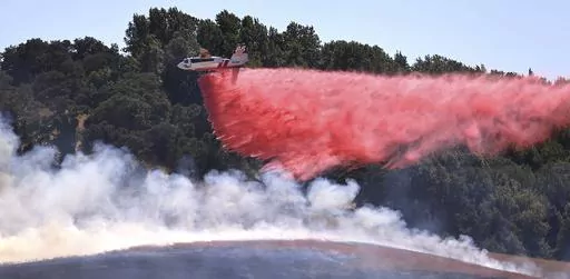 A pilot maneuvers Cal Fire tanker 85 from the Sonoma Air Attack Base for a drop on the right flank of the San Antonio Fire, west of Petaluma, Ca., Friday, June 30, 2023. California is in the middle of a heat wave during the long Fourth of July weekend. (Kent Porter/The Press Democrat via AP)