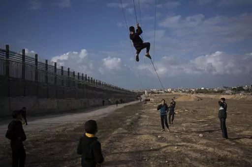 Palestinians displaced by the Israeli bombardment of the northern Gaza Strip play next to the border with Egypt, in Rafah, southern Gaza, Sunday, Jan. 14, 2024. Israel and Egypt are engaged in an increasingly public spat over a narrow strip of land between Egypt and Gaza. That strip is the Philadelpi Corridor. The dispute puts Israel in a bind. If it stops its military offensive against Hamas without taking control of the southern Gaza city Rafah on the border with Egypt, it falls short on its t