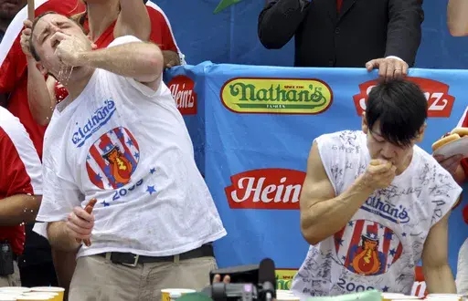 Joey Chestnut, defending champion of the Nathan’s Famous Fourth of July hot dog eating contest, left, works to outpace former champion Takeru Kobayashi, right, July 4, 2009, in New York. Chestnut, a 16-time hot dog-eating champion, will face off with his frequent Nathan’s competitor, Kobayashi, in a live Netflix special on Sept. 2, 2024, the streamer announced Wednesday, June 12. (AP Photo/Craig Ruttle, File)