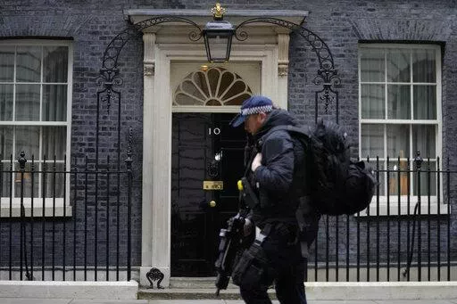 A police officer walks past 10 Downing Street in London, Tuesday, Jan. 25, 2022. London police say they are now investigating Downing Street parties during lockdown. Metropolitan Police Commissioner Cressida Dick revealed an investigation was underway in a statement before the London Assembly on Tuesday. Dick said Scotland Yard is now investigating "a number of events" at Downing Street. (AP Photo/Kirsty Wigglesworth)